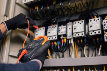 Wall Mural - Electrician engineer work tester measuring voltage and current of power electric line in electical cabinet control.and wires on relay protection system. Bay control unit. Medium voltage switchgear.