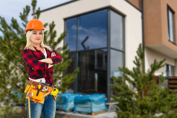 Wall Mural - Happy woman on the background of a new house. Portrait of first time buyer, house owner, apartment renter, flat tenant or landlady. Moving day and buying own property concept