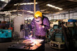 © Thirawatana - Factory technicians are welding young.  Metal welding steel works using electric arc welding machine to weld steel at factory.