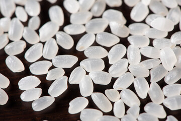 Wall Mural - Close-up raw white grains of rice on wood background