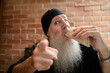 Man with long gray beard eating taco
