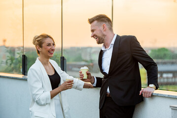 Wall Mural - Businesspeople drinking coffee on a rooftop during sunset