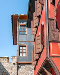 Colorful medieval houses and part of stone wall of ancient gate in Architectural and Historical Reserve Ancient Plovdiv or Old Town. Tourist landmarks of Plovdiv city, Bulgaria. Vertical, copy space