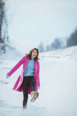 Poster - Shallow focus shot of a beautiful Caucasian woman with glasses posing in the snowy forest