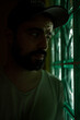 © Alex Sobrino - Portrait of a man with beard in the dark looking through a glass brick wall