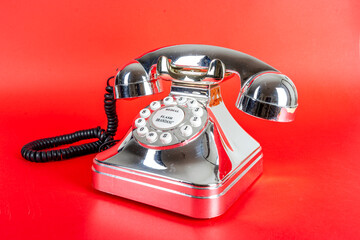 chrome vintage telephone on a red background