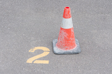 traffic cone in a parking lot near space number two