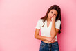 © Asier - Young Indian woman isolated on pink background who feels sad and pensive, looking at copy space.