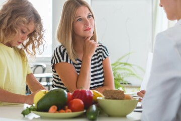 Canvas Print - Cute boy and professional dietitian preparing a diet eating plan