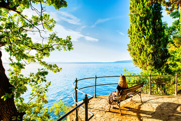 Wall Mural - Woman relaxing with her pet by the sea