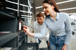 © fotofabrika - Young couple choosing new electric oven in hypermarket