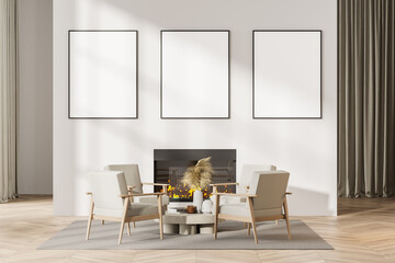 Contemporary white living room interior with fireplace, armchairs. Three posters in a row template mockup on wall.