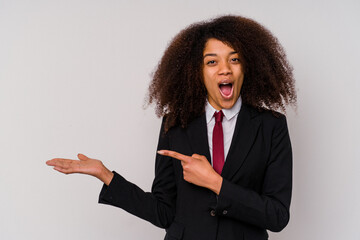 Wall Mural - Young African American business woman wearing a suit isolated on white background excited holding a copy space on palm.