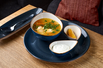 Wall Mural - chicken soup with egg noodles on a wooden table.