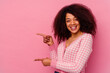 Young african american woman isolated on pink background excited pointing with forefingers away.