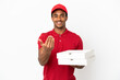 © luismolinero - African American pizza delivery man picking up pizza boxes over isolated white wall inviting to come with hand. Happy that you came
