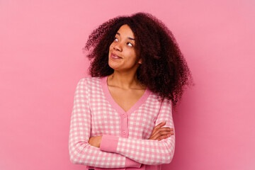 Young african american woman isolated on pink background dreaming of achieving goals and purposes