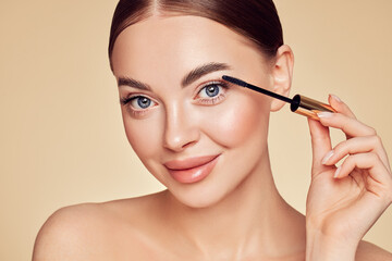 Wall Mural - beauty woman applying black mascara on eyelashes with makeup brush. eyelash extensions. makeup, cosm
