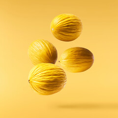 Fresh raw melon falling in the air isolated on yellow