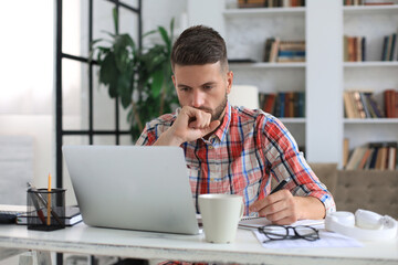 Wall Mural - Happy young business man is analizing financial documents from home during self isolation.