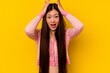 © Asier - Young chinese woman isolated on yellow background screaming, very excited, passionate, satisfied with something.
