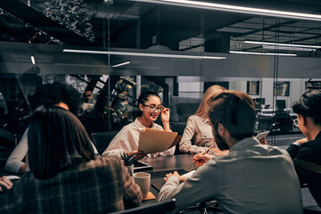 Work in the office. Beautiful muslim business woman working in the office surrounded by her colleagues.