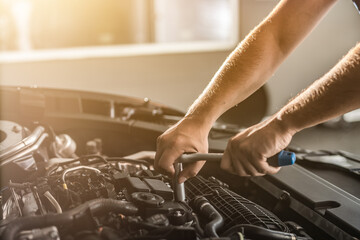 Auto mechanic working and repair on car engine in mechanics garage. Car service.