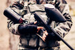 A sports paintball weapon in the hand of a young boy
