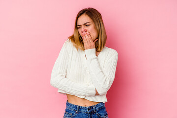 Sticker - Young caucasian woman isolated on pink background yawning showing a tired gesture covering mouth with hand.