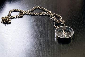 compass on a chain on a wooden table