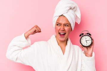 Poster - Young venezuelan woman late for work isolated on pink background raising fist after a victory, winner concept.