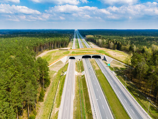 Expressway with ecoduct crossing - bridge over a motorway that allows wildlife to safely cross over the road, aerial top down view