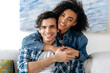 © Kateryna - Portrait of a happy mixed race couple in love. Pretty african american curly girl and hispanic attractive guy tenderly hugging each other, looking at the camera, smiling, happy family