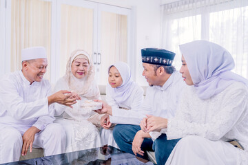 Wall Mural - Muslim man sharing cookies to his family at Eid