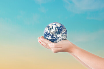 Canvas Print - environment day concept, globe in child hands over blue sky background. save of earth. elements of t