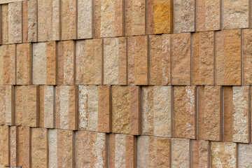 Canvas Print - This image shows a rough texture stone wall background with attractive narrow vertical kasota limestone blocks in varying widths, and shades of brown and beige