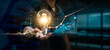 © ipopba - Businessman holding creative light bulb with growth graph and banking icons. Financial innovation technology develop new products and services that enhance successful and profit in global business.