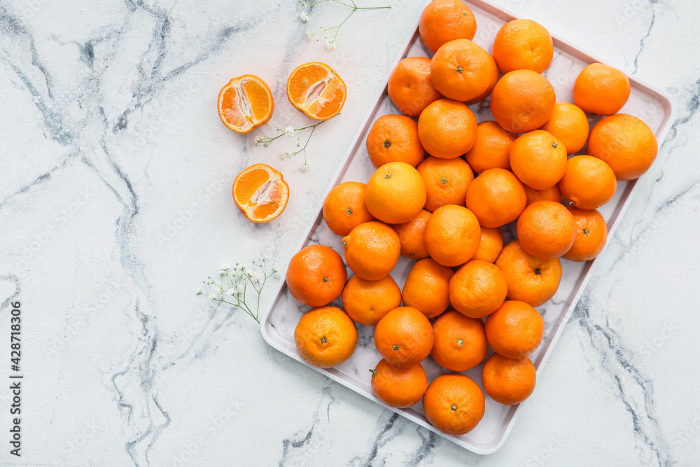 Tray with sweet tangerines on light background