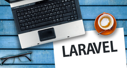 Laravel PHP Framework programming language. Word Laravel on paper and laptop