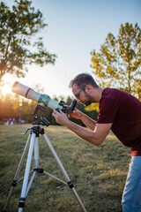 Wall Mural - amateur astronomer looking at the sky with a telescope.