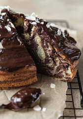 Wall Mural - Piece of homemade marble cake with chocolate glaze and nuts on wooden plate. Chocolate vanilla zebra pie.