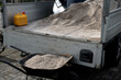 after pruning a bunch of lawn, gardeners apply silica white sand. for better structure and airiness against grass mold. load on a wheelbarrow from the body of a truck