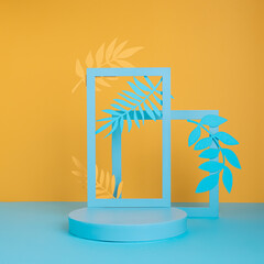 Tropical empty product podium with palm leaves and frame for copy space on two tone blue and yellow background. Concept scene stage for promotion, sale, presentation or cosmetic. Summer jungle layout.