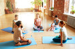 © Syda Productions - fitness, sport and healthy lifestyle concept - group of people with water bottles and towels in yoga class resting on mats at studio
