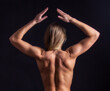 muscular back of a woman on black background