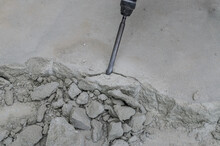 A Builder Dismantles A Perforator Drill Breaks The Concrete Floor At A Construction Site