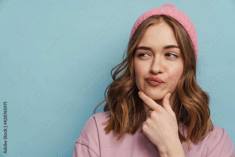 Young white woman thinking and touching her chin - obrazy, fototapety, plakaty 