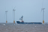 Fototapeta Zwierzęta - Zero carbon emission electricty production. Supply ship between wind turbines
