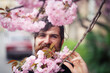 © endrews21 - Bearded adult man with long mustache and gray hair near cherry blossom trees in spring