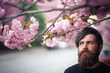 © endrews21 - Charismatic bearded adult man with long mustache and gray hair near cherry blossom trees in spring